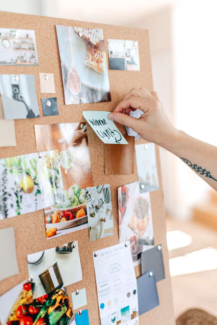 photographer planning out the clients mood board and photoshoot on a cork board