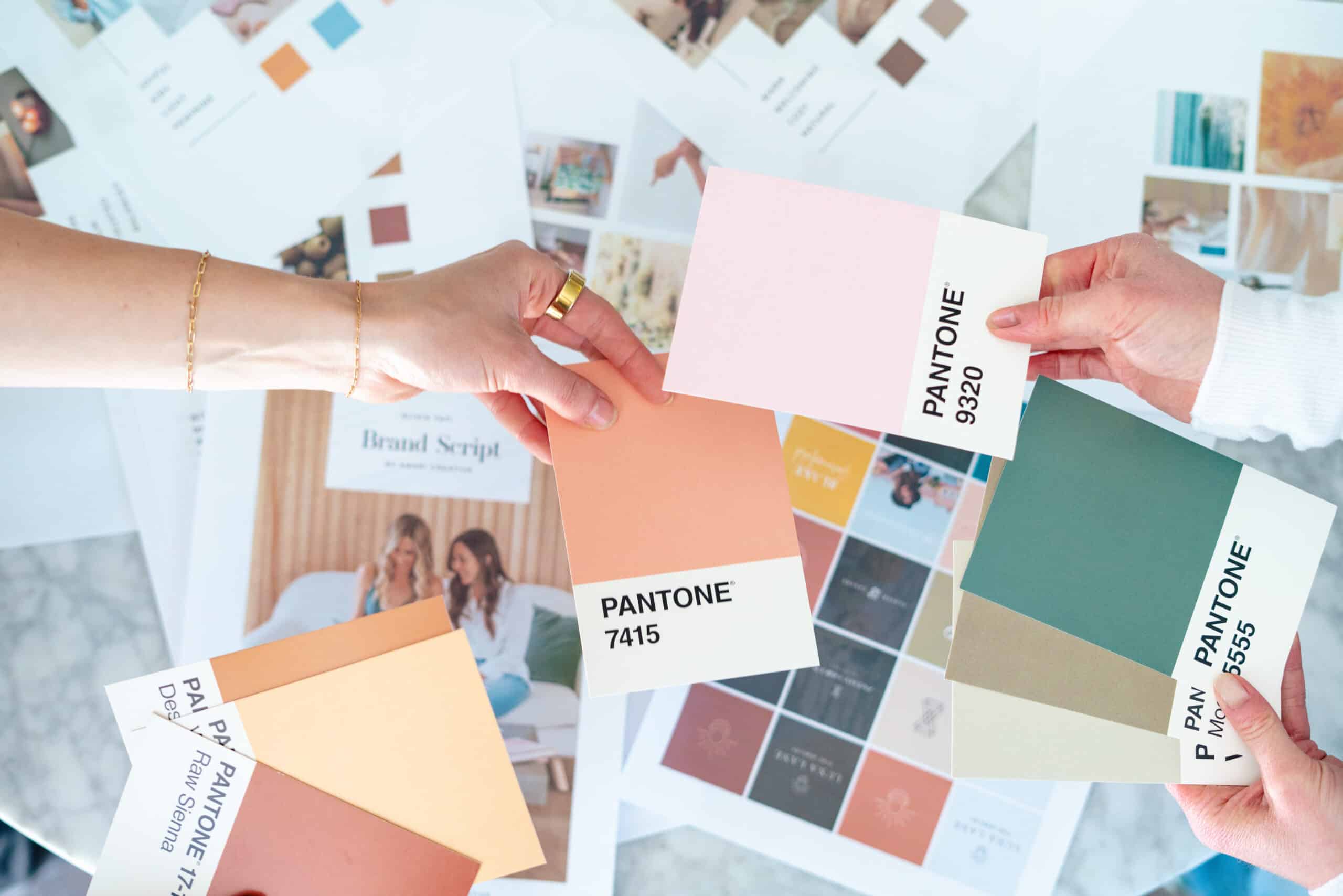 branding photography in san diego of pantone colors being passed back and forth over a table of brainstorming and branding images gina ribando